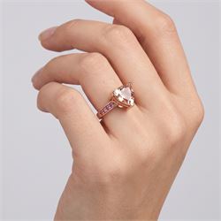 9ct rose gold morganite and tourmaline ring, single trilliant cut morganite of approx 5.35 carat, each shoulder set with four round cut tourmalines, Birmingham 2011