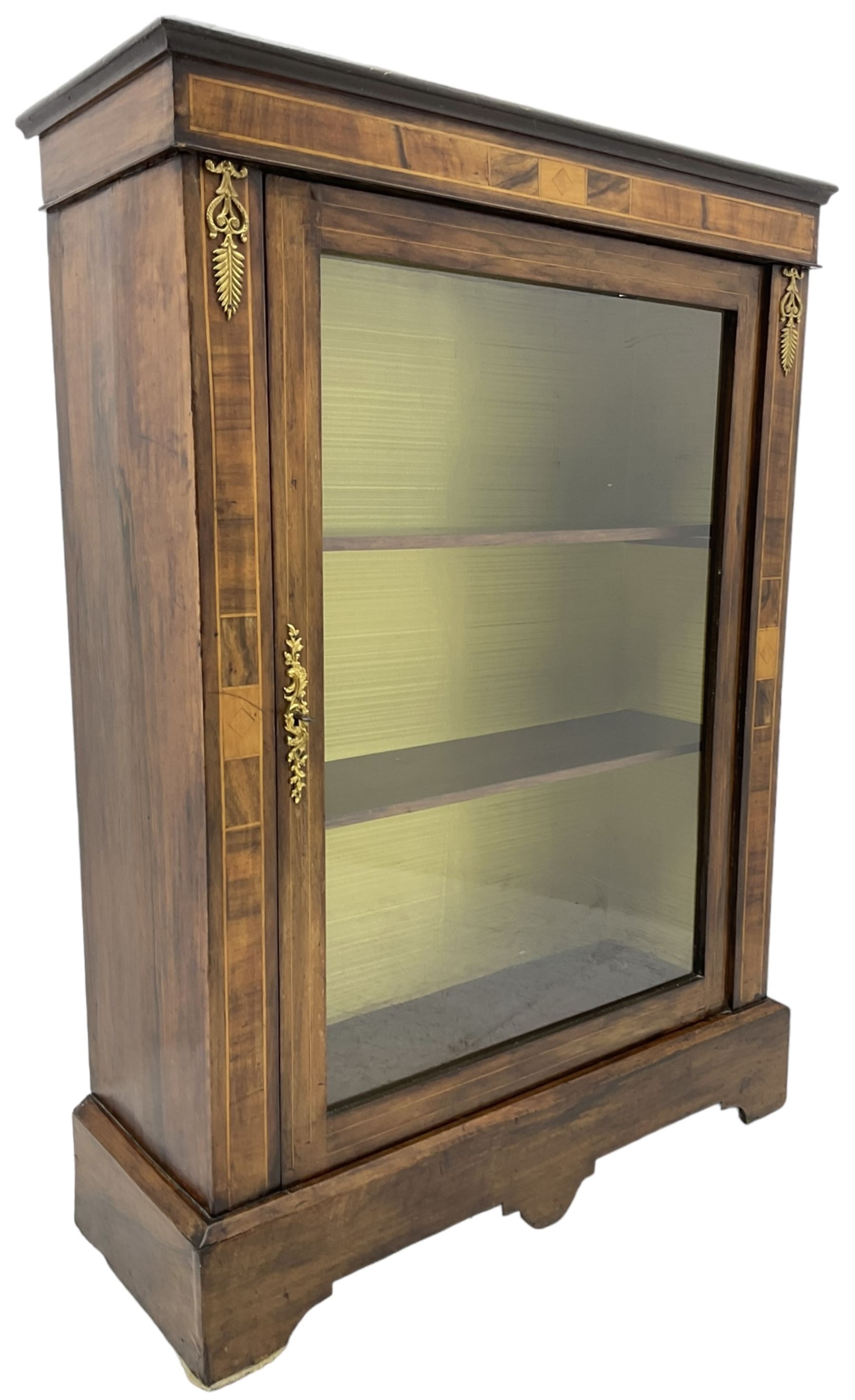 Victorian walnut pier cabinet, moulded rectangular top over inlaid frieze and uprights, enclosing by single glazed door, the interior fitted with two shelves, on shaped bracketed plinth base