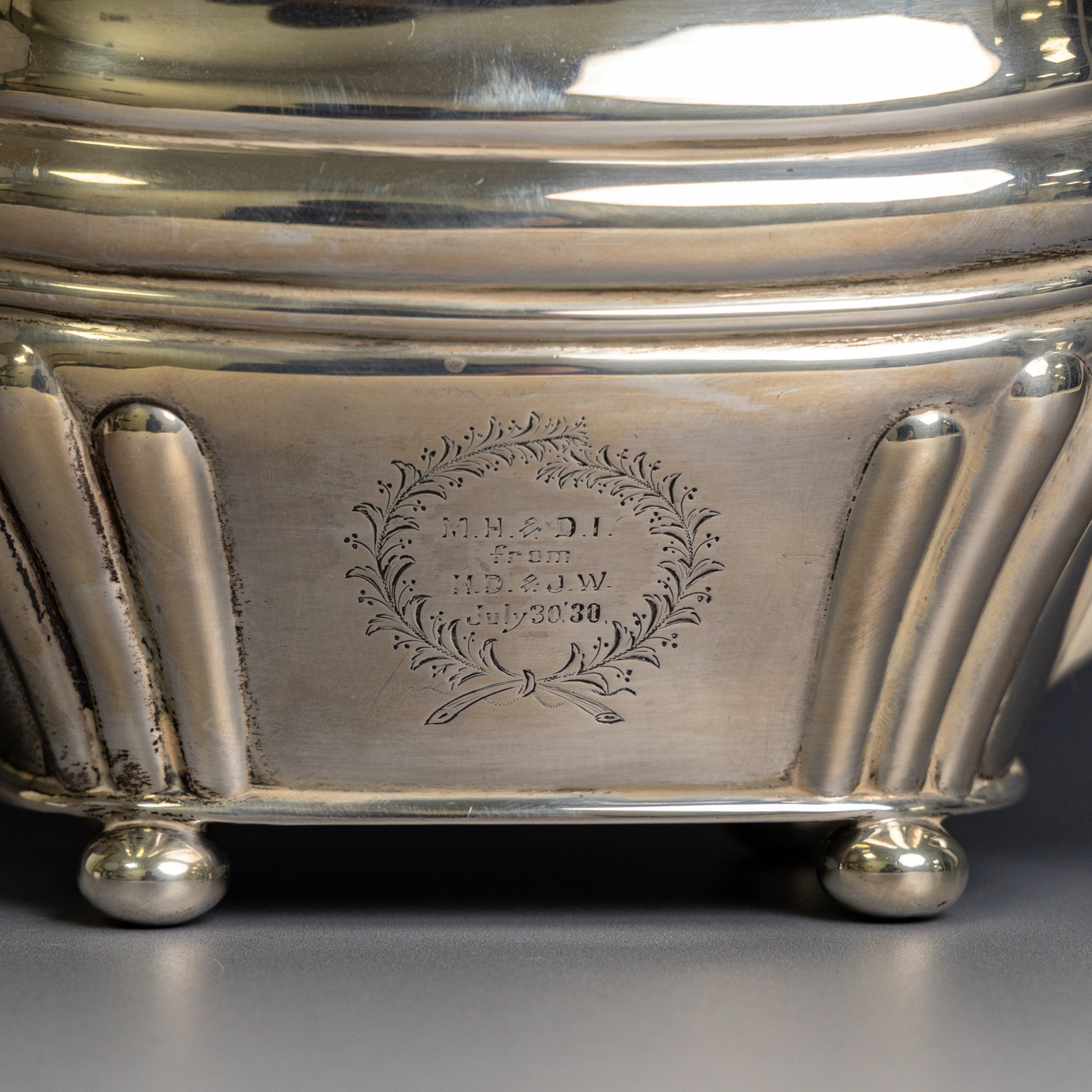 Edwardian silver teapot, of part fluted oval form upon four bun feet, with ebonised handle and finial and presentation engraving to body, hallmarked Thomas Bradbury & Sons, London 1904, H17cm