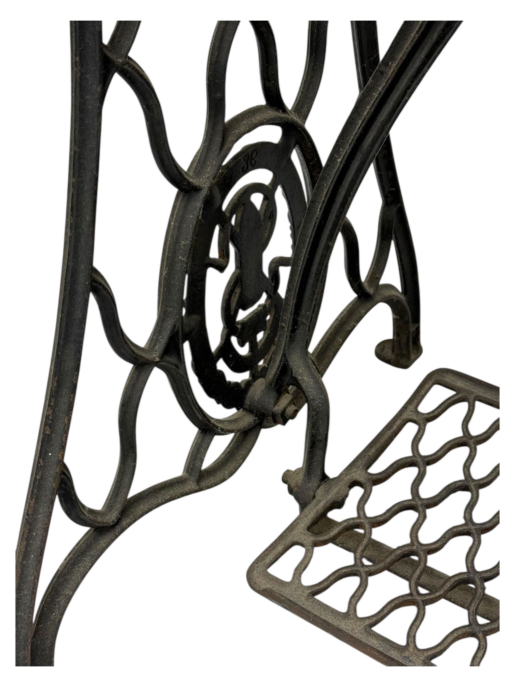 Singer - early 20th century cast iron treadle sewing machine, with hand crank wheel and oak work surface, the machine decorated with gilt foliate detail, complete with rectangular wooden cover and folding extension leaf