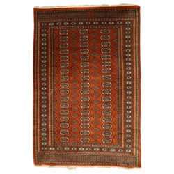 Bokhara hand-knotted carpet, terracotta ground with repeating rows of Tekke guls intersper...