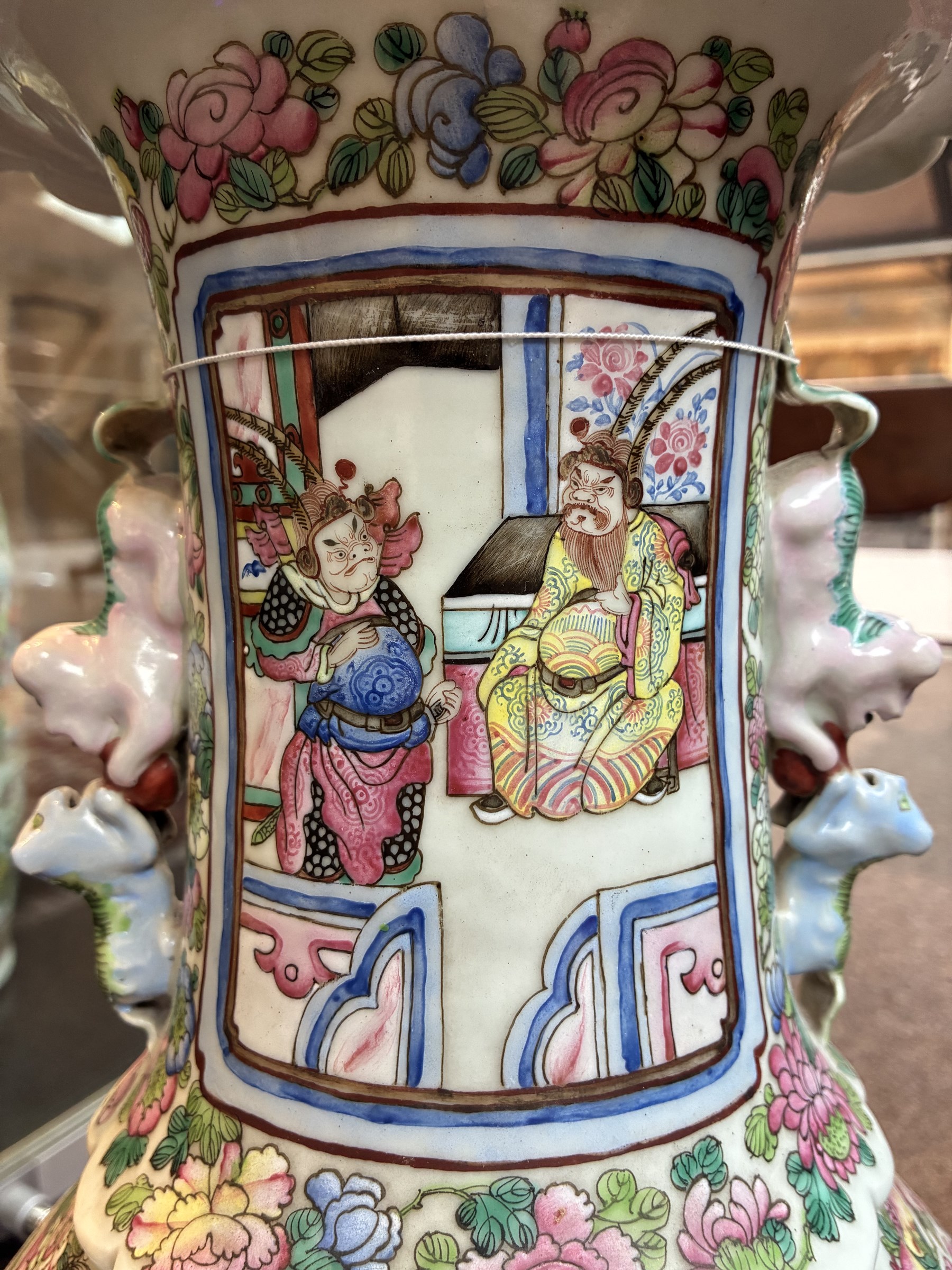 Large pair of 19th century Cantonese famille rose vases, each painted with various courtly scenes, including a display of warriors fighting on horseback before an official and his attendants, double Buddhist lion handles and applied at the shoulders with chilong, the lower band painted with Greek key motif, H58cm (2)
