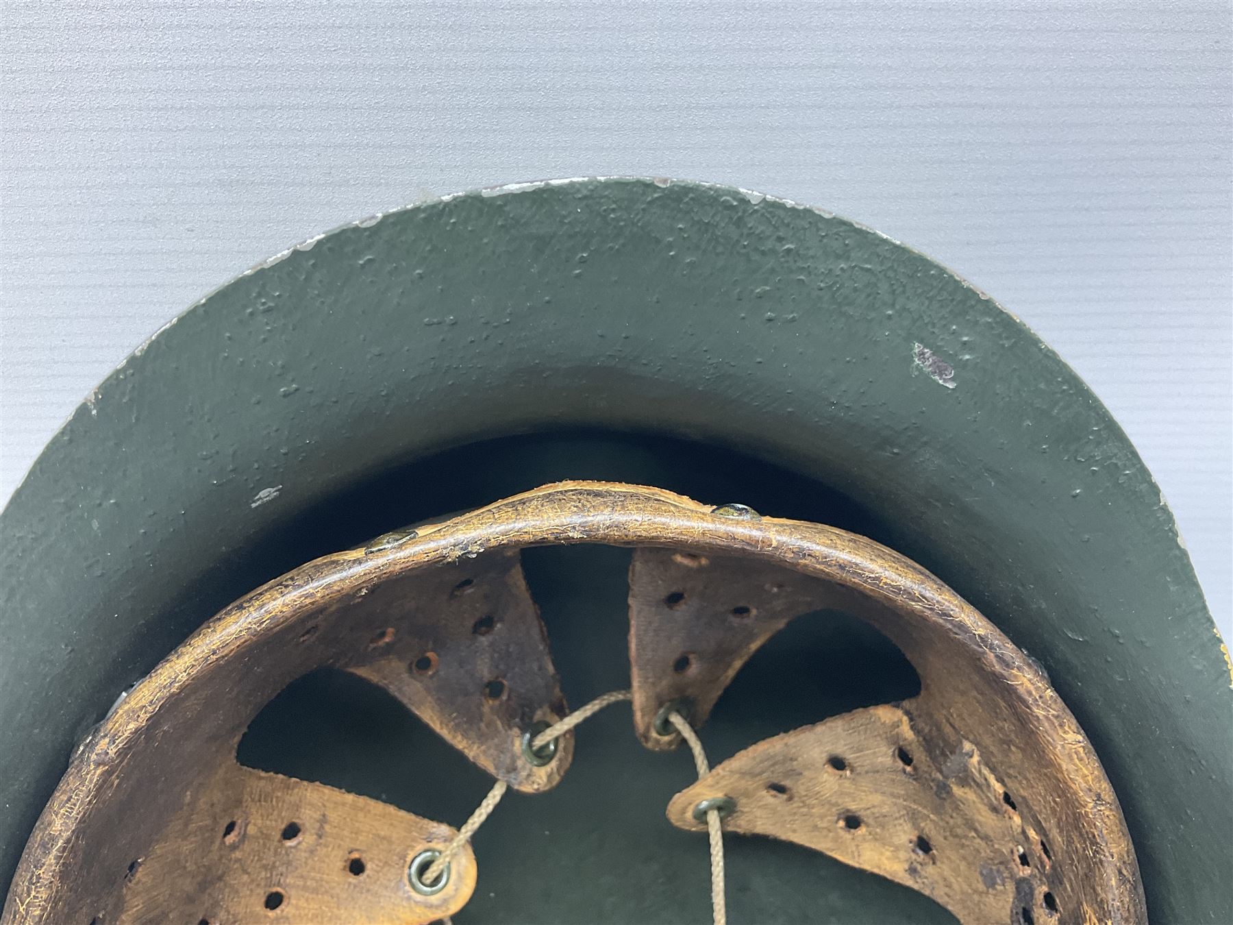 Fully restored German steel helmet, the camouflage painted exterior with two decals and replacement leather liner