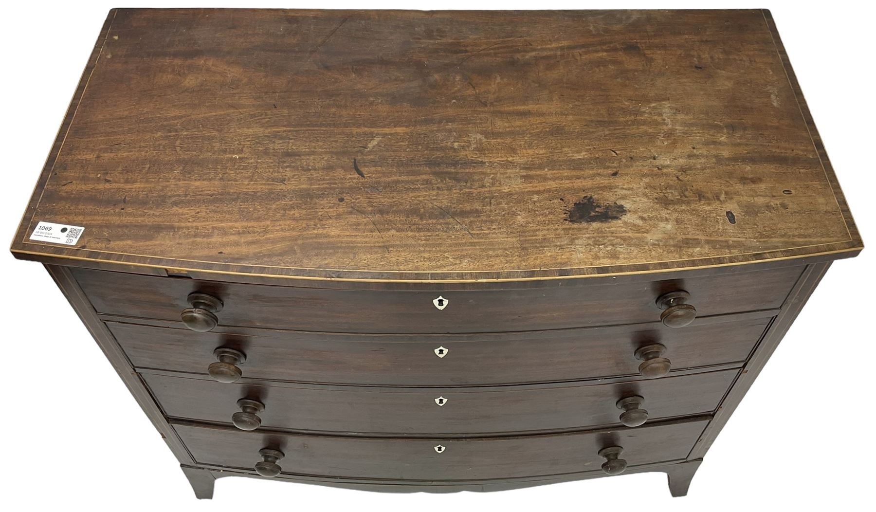 George III mahogany bow-front chest, crossbanded top with satinwood stringing, fitted with four graduating cock-beaded drawers, each with bone shield shaped escutcheons and turned handles, shaped apron flanked by splayed feet