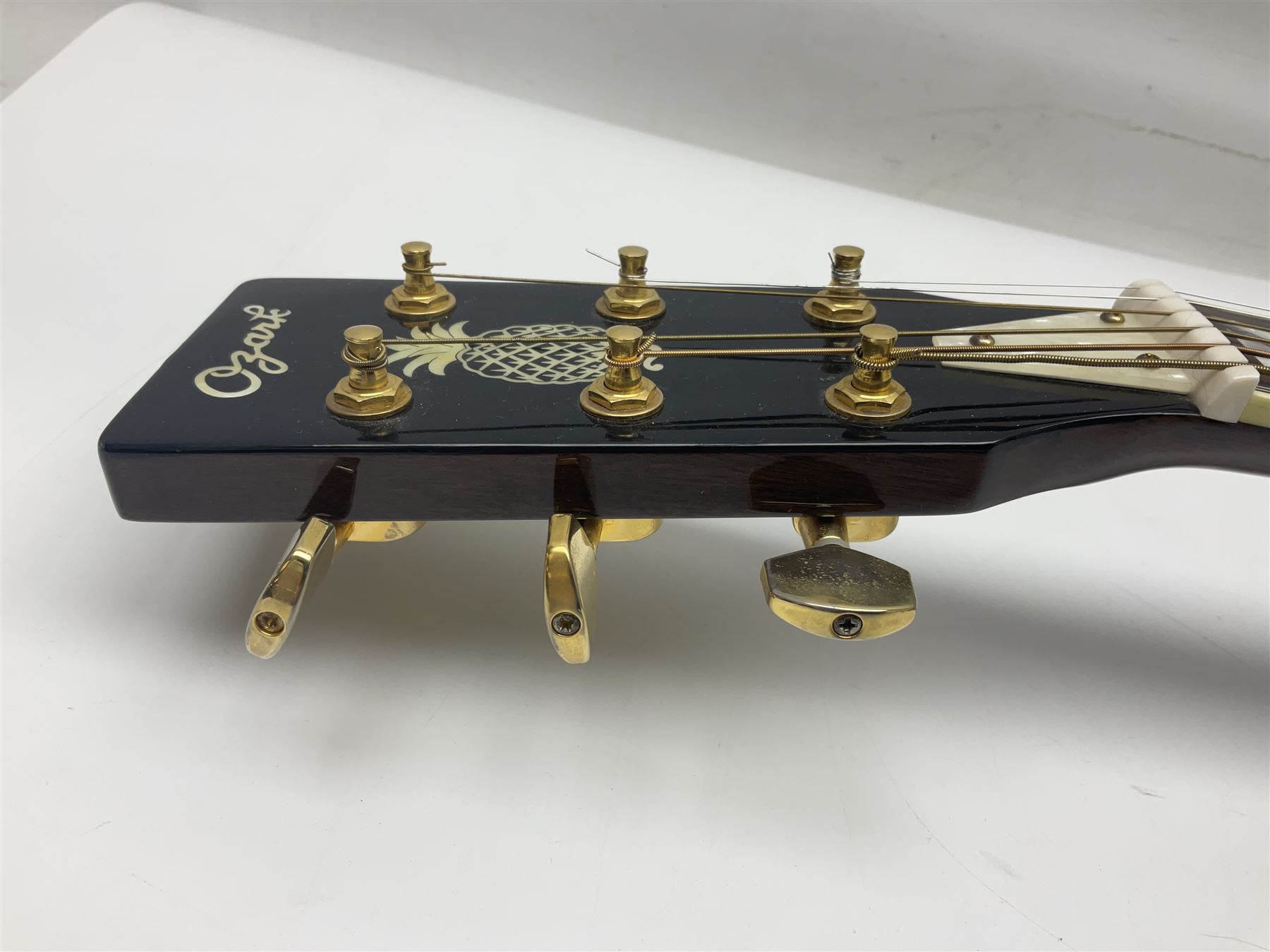 Ozark metal cased resonator guitar with all over chased foliate decoration to the polished finish and mother-of-pearl inlay to the fretboard L100cm; in Stagg hard carrying case