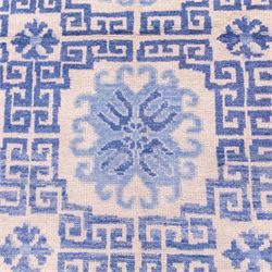 Late 20th century Chinese hand-woven wool carpet, ivory field with a lattice of stylized lotus medallions, contained within geometric key fret panels interspersed with a small floral device enclosed within a complementary Greek-Key border, the designs in tones of pale blue and soft cream