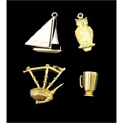 Four 9ct gold charms including sailing boat, owl, mug and bagpipes