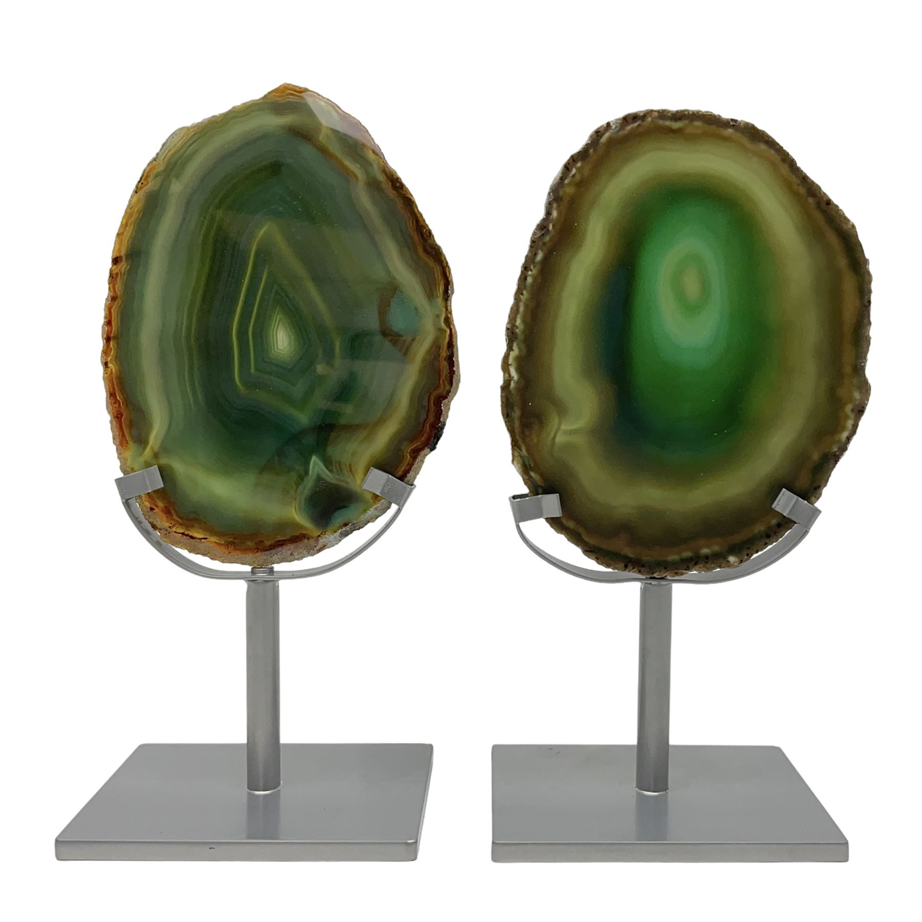 Pair of green agate slices, polished with rough edges raised upon silvered metal stands, H19cm