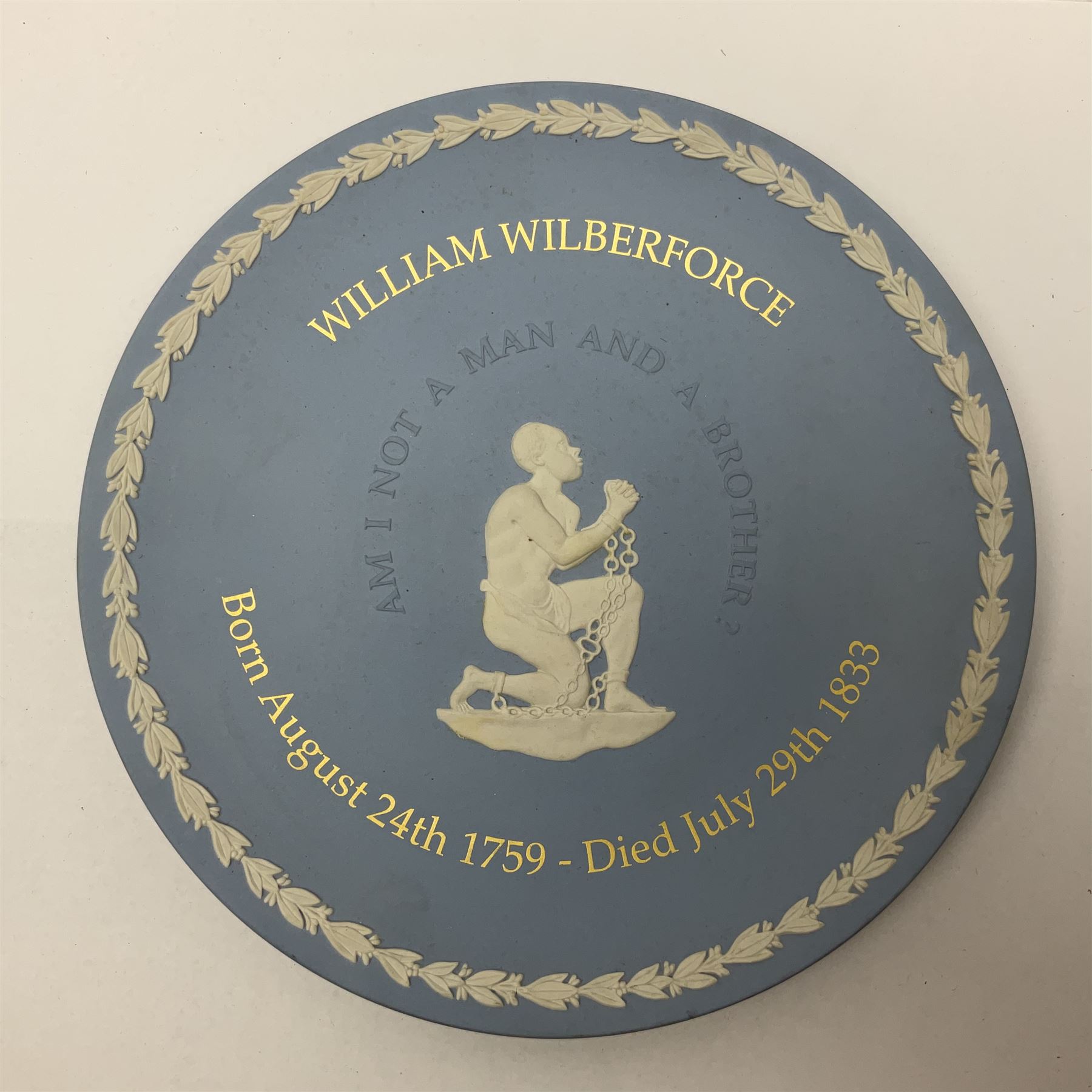 Group of William Wilberforce Abolition of Slavery items, comprising Wedgwood black on cane Jasperware pin tray, Wedgwood light blue Jasperware plate, and two Wedgwood oval medallion pendants, each depicting a kneeling figure beneath the inscription 'AM I NOT A MAN AND A BROTHER?', an Eastgate pottery plaque decorated in relief with a kneeling figure before William Wilberforce, a Hull Museum Publications pamphlet titled 'Medals, Tokens, etc., Issued in Connection with William Wilberforce and the Abolition of Slavery', by Thomas Sheppard, dated 1916, and an antique print depicting William Wilberforce after the original portrait by George Richmond, (7)