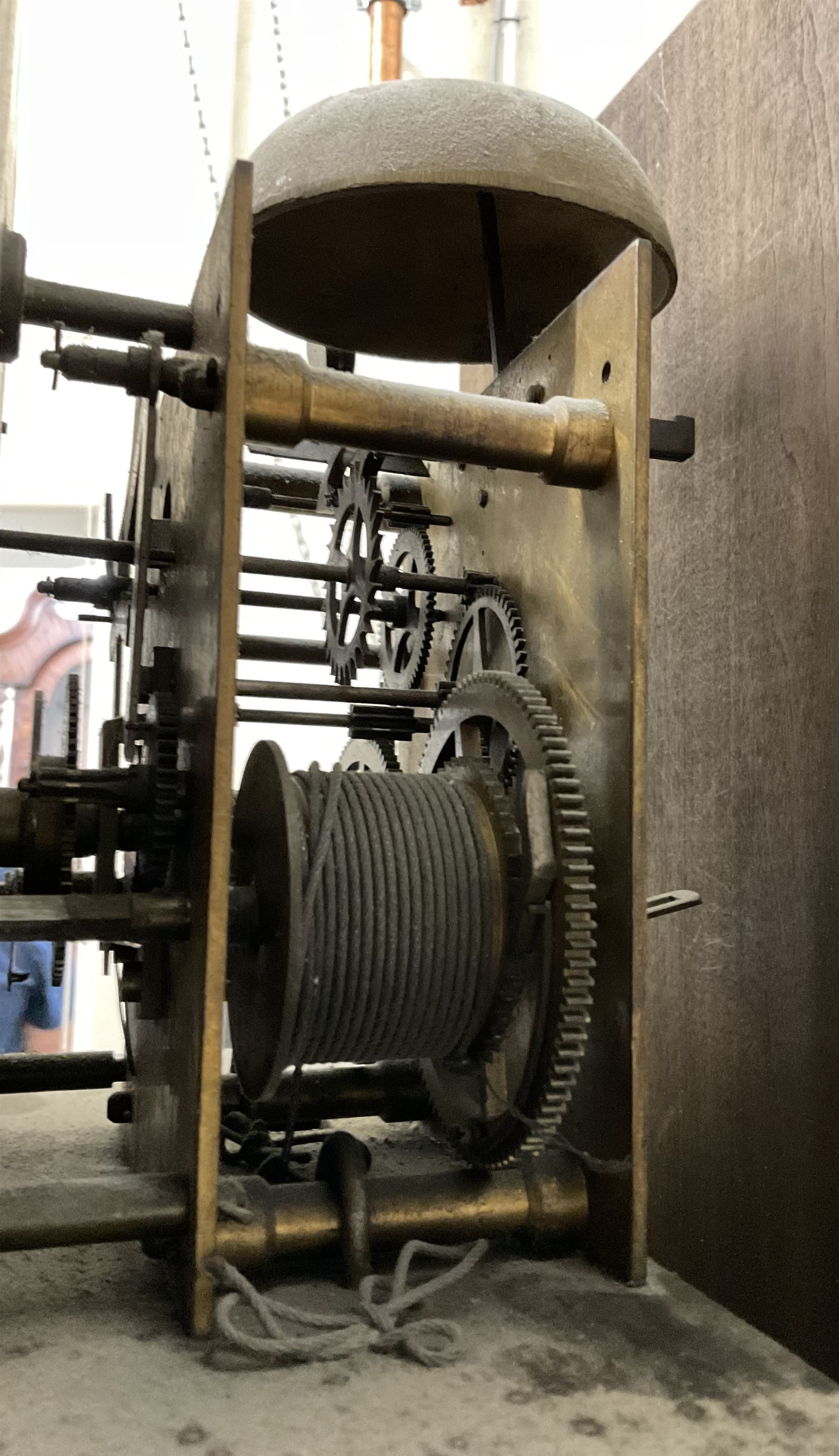 8-day oak longcase clock - in an early 18th century styled case with a caddy top, square hood door with barley twist columns, long carved trunk door on a conforming plinth with an applied skirting base, square brass dial with an engraved centre, silvered chapter and spandrels, 19th century rack striking movement, striking the hours on a bell. With weights and pendulum.