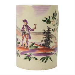 18th century Leeds creamware mug, circa 1770, of cylindrical form with curved strap handle, painted in purple, red and green with a peasant toasting with a glass of ale within a bucolic setting, H12.5cm