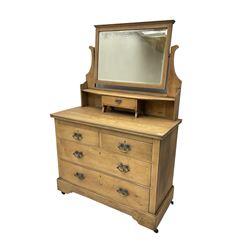 Art and Crafts period oak dressing chest, the rectangular bevelled swing mirror over single small drawer, rectangular top over two short and two long drawers, on plinth base with bracket feet, tooled and shaped copper plates and brass handles