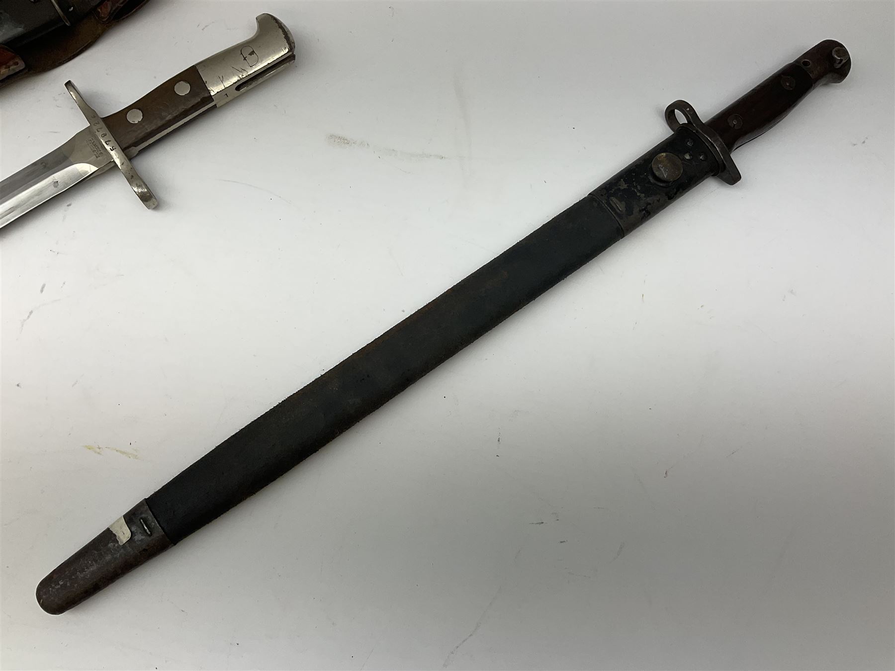 British Enfield 1907 model SMLE bayonet, with 43cm fullered steel blade and metal mounted leather scabbard L58cm overall; and Schmidt-Rubin Model 1918 bayonet the 30cm steel blade marked Elsener Schwyz No.579722; in steel scabbard with leather frog marked G. Bertolini Sellaio Vira/G.Tic 79 L45cm overall (2)