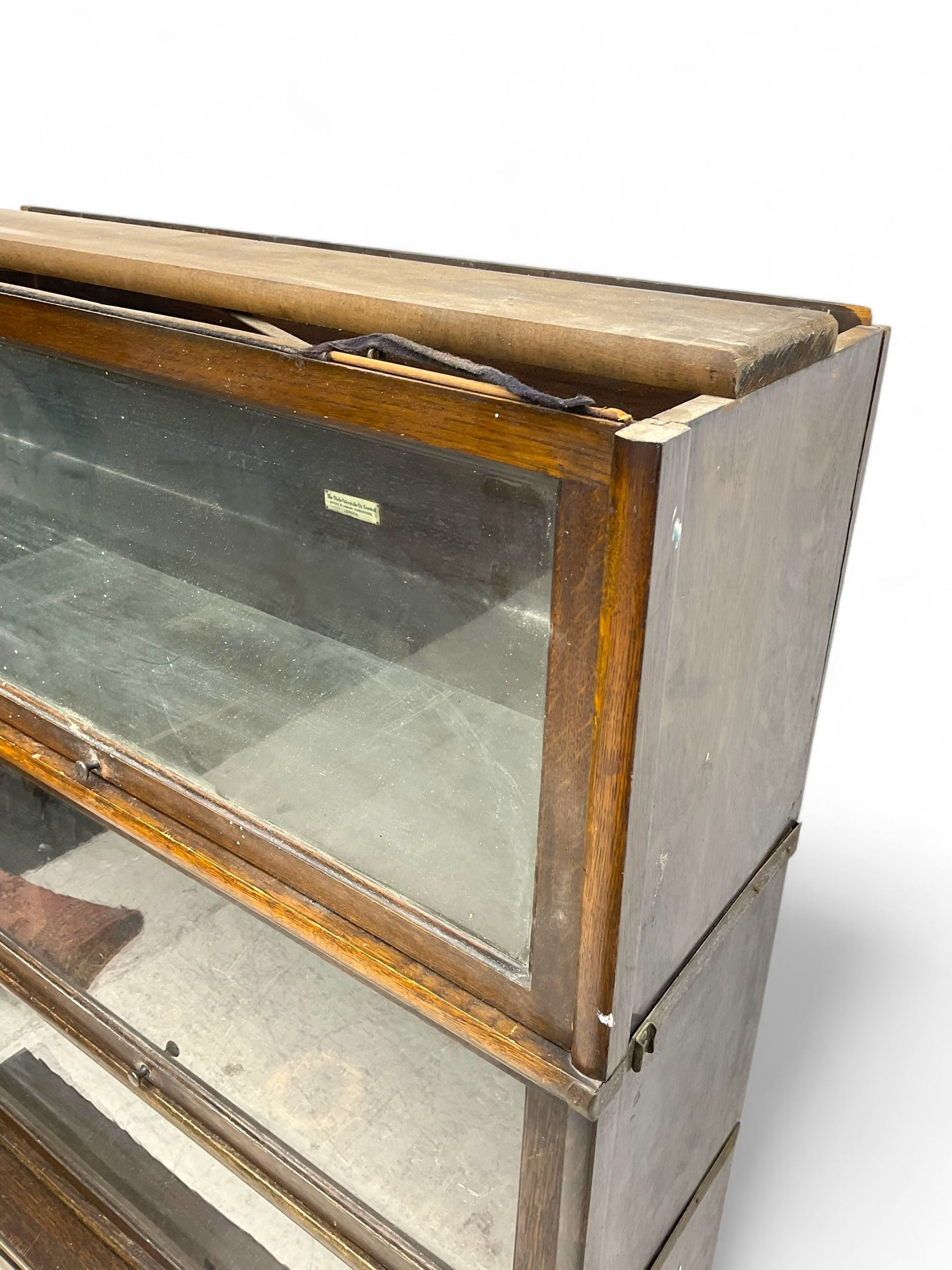 Globe Wernicke - early 20th century oak four-tier stacking library bookcase, four glazed sections enclosed by hinged and sliding doors