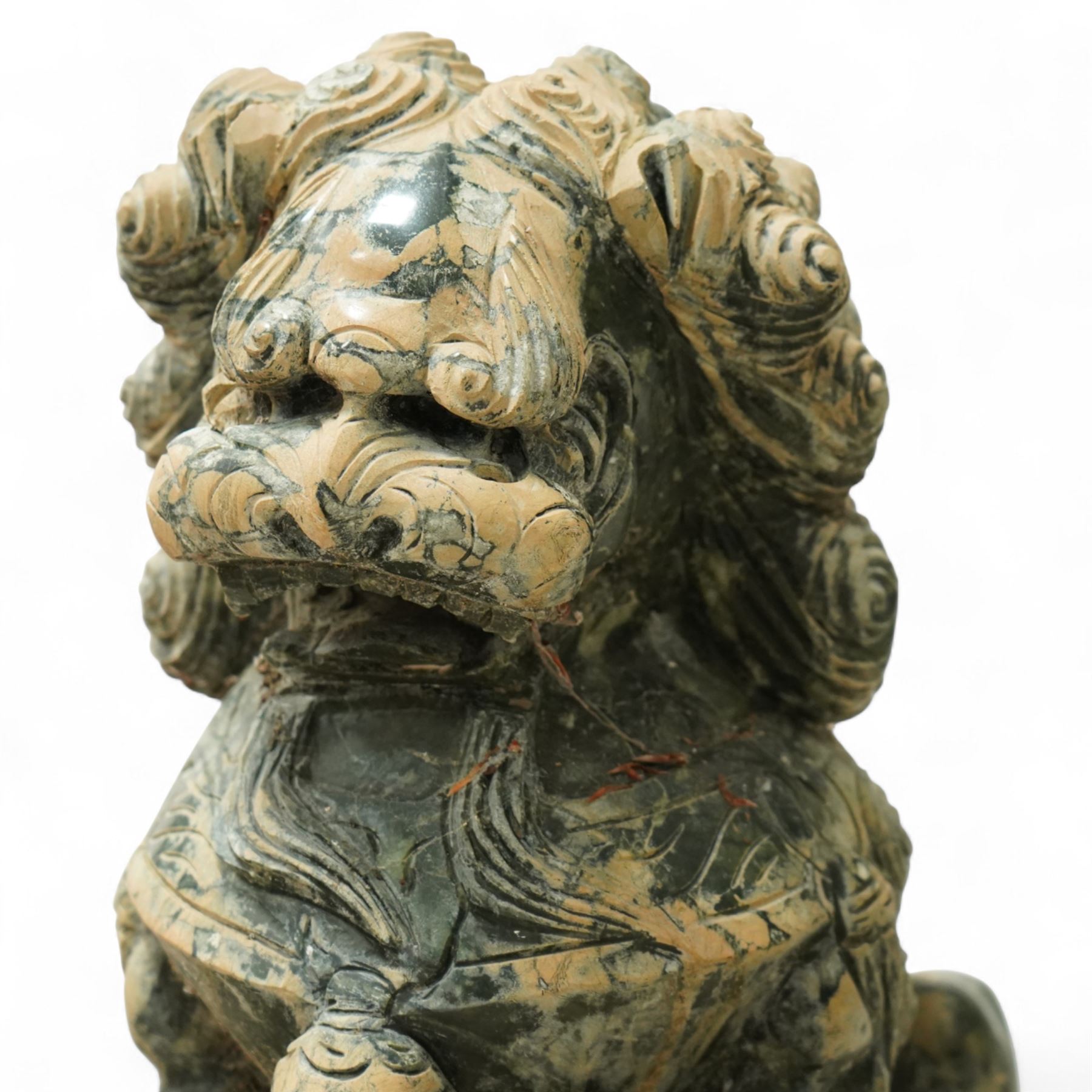 Pair of Chinese hardstone carved Foo dogs, each finely carved seated on rectangular plinth bases with detailed manes, collars and bells, the male with paw resting on a ball, the female with cub, in mottled green stone resembling jade