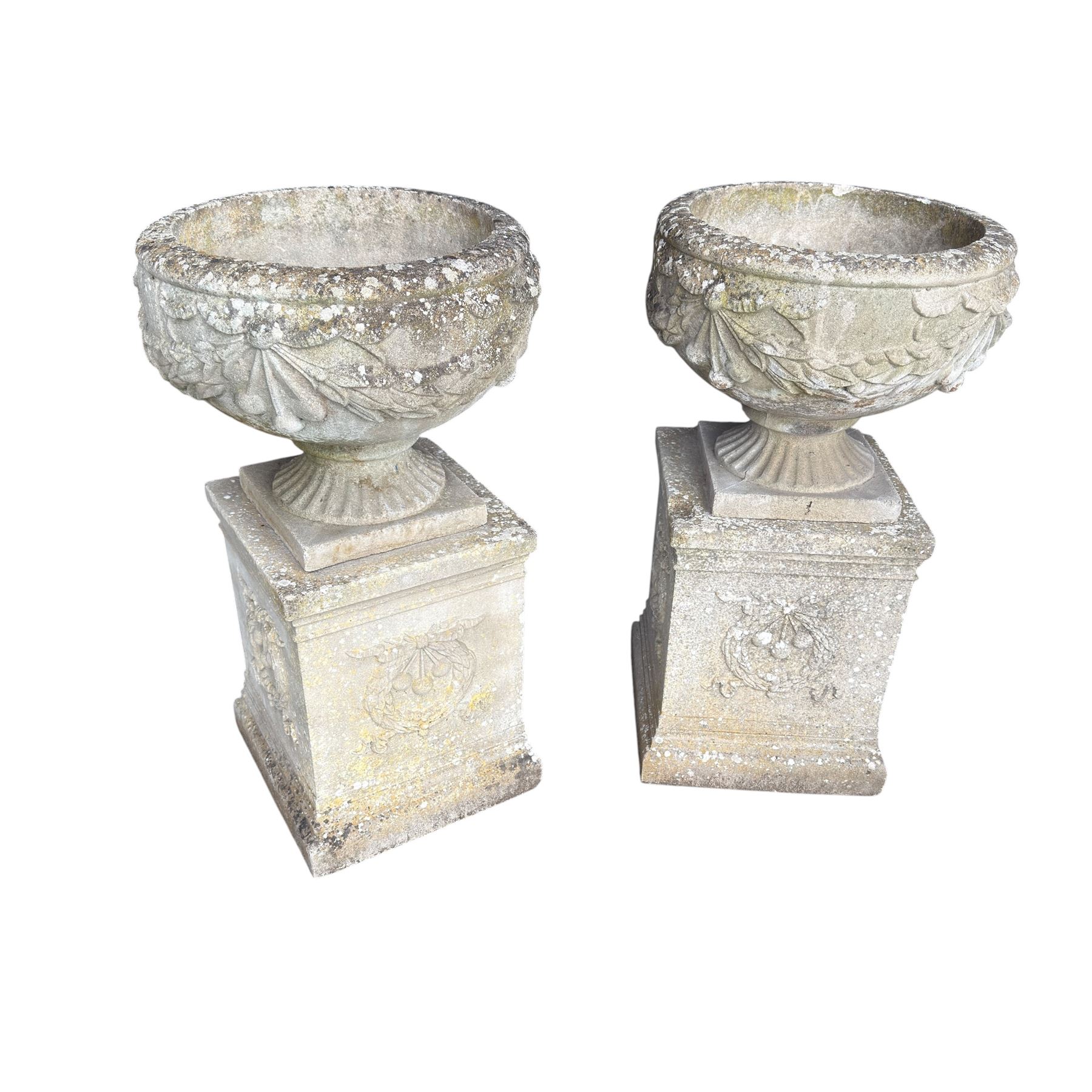 Pair of quality Neoclassical design Haddonstone cast stone garden urns, the globular  body decorated with relief foliate festoons and fruiting motifs, over a fluted socle, the rectangular pedestals with relief foliate wreaths and ribbon garlands