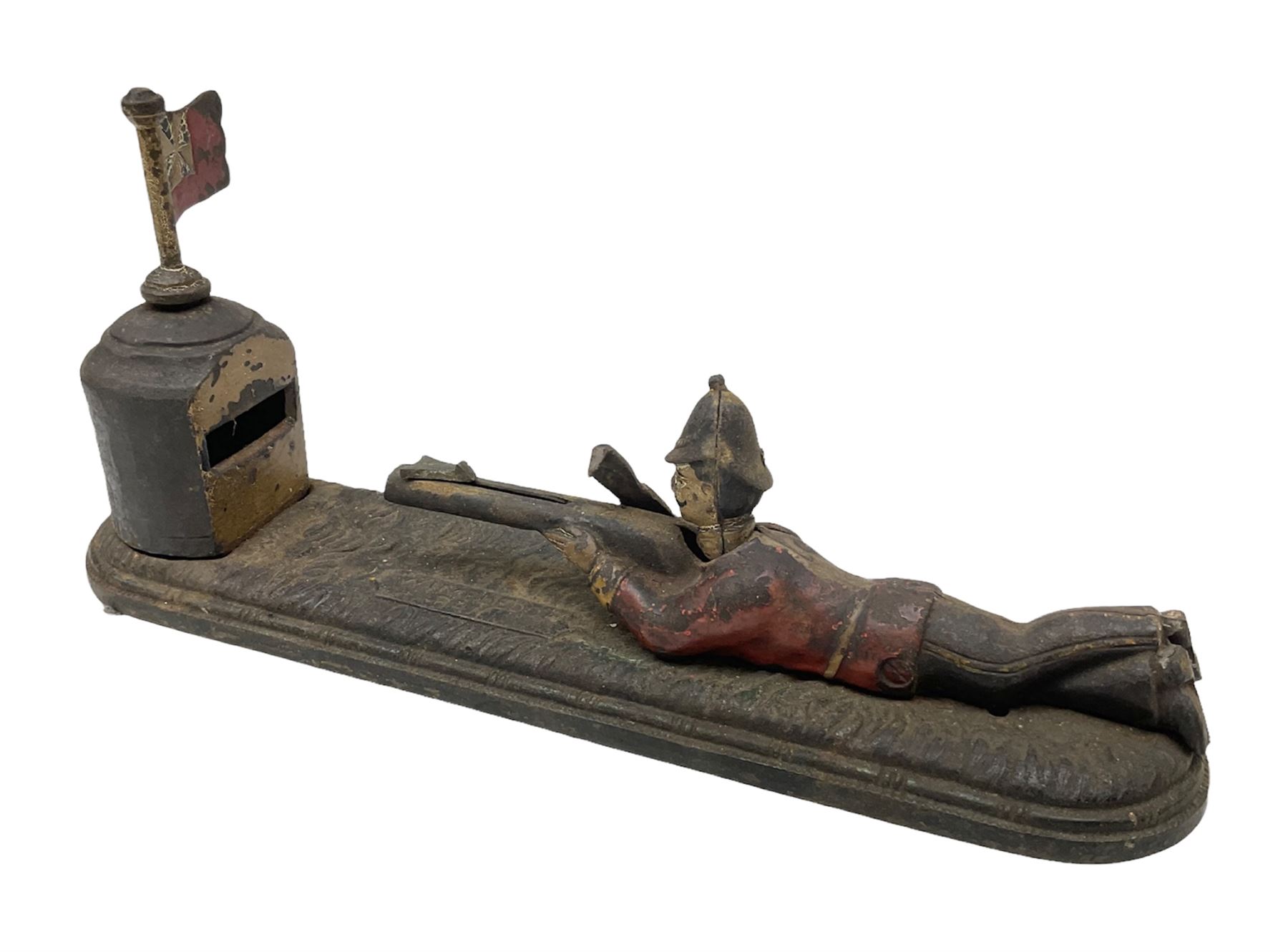 Very rare 19th century John Harper & Co. mechanical cast-iron money box, registered number 33821 patented 1885, inscribed on metal plaque 'Wimbledon Bank', based on the Queen's Trophy for shooting at Wimbledon, depicting a British Infantry man in red tunic and blue trousers lying on the ground using a gun to fire a brass coin launcher into a pill box with fixed flag above L30cm
