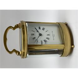 Late 20th century carriage timepiece clock, polished brass case of oval form glazed with bevelled glass panels, white enamel Roman dial signed 'by Collingwood & Sons, Paris', eight day movement, shaped handle