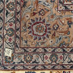 Kashan Persian rug, hand knotted, ivory ground rug, the rosette medallion decorated with projecting palmettes, on a field of swirling leafy branches and decorated with further palmettes, the scrolling border with repeating stylised plant motifs, within floral pattern guard stripes