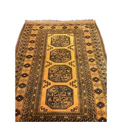 Bokhara gold ground rug, the field decorated with four Gul motifs, wide multi-band border, repeating design and decorated with stylised motifs 