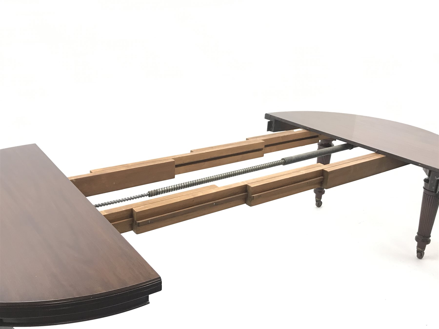 Spillman & Co. London - large Victorian mahogany extending dining table with three additional leaves, on turned and reeded supports with ceramic castors, ivorine label to underneath 'Spillman & Co. St. Martins Lane, London', diameter - 137cm (closed), L302cm (with all leaves)