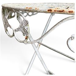 Three-piece French style white-painted wrought iron garden bistro set, comprising a circular folding table with latticework top and apron with scrolling foliate motifs (W70cm H80cm) and matching pair of chairs, with scrolling cresting rail and acorn finials over a scrolled foliate medallion, raised on lattice seat and folding X-frame base (W42cm H93cm)