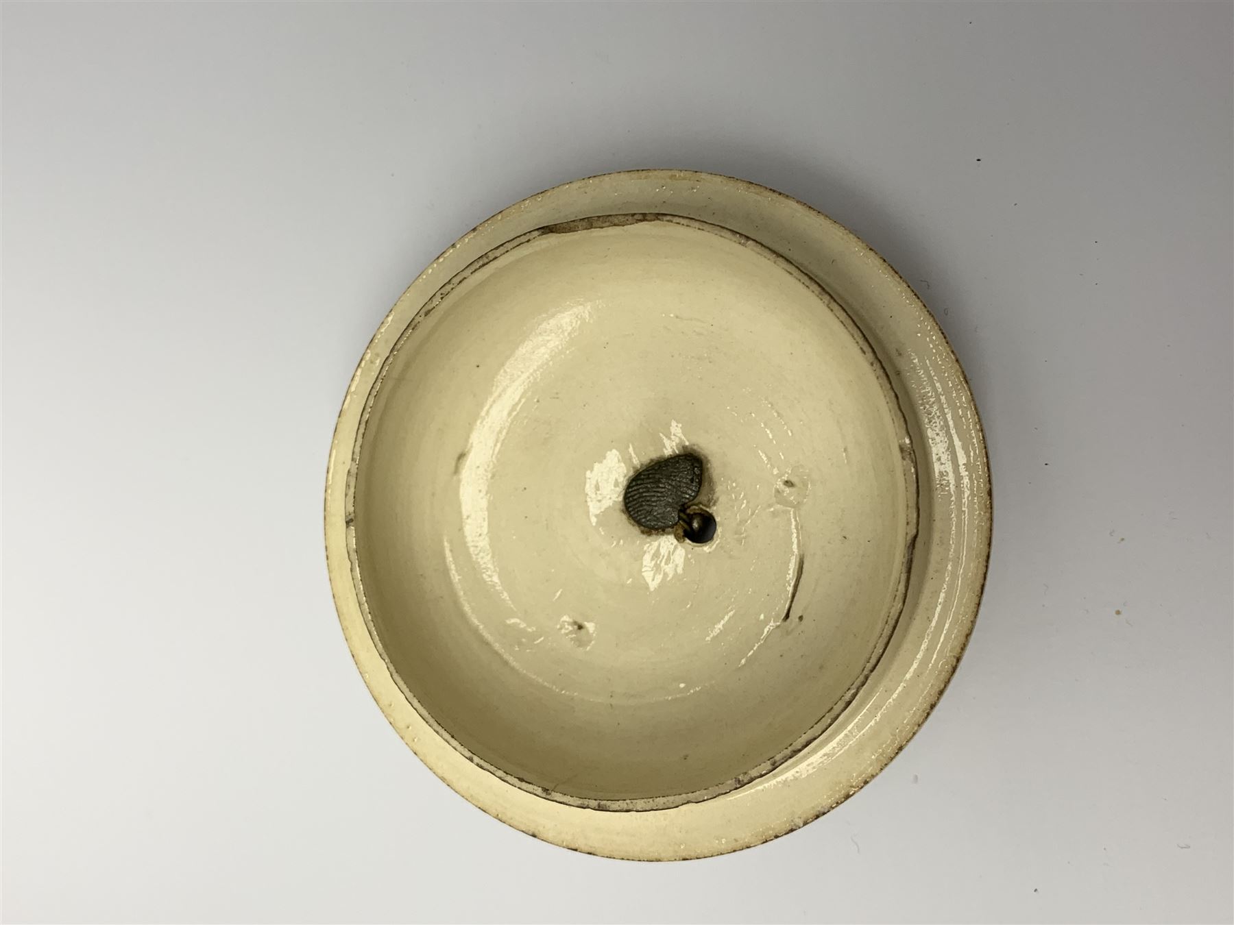 18th century creamware teapot, probably Leeds, with reeded entwined handle and floral finial to the cover, the body with hand painted polychrome decoration of figure to one side, and floral spray to the other, collectors paper label beneath inscribed Leeds Pottery, H11.5cm