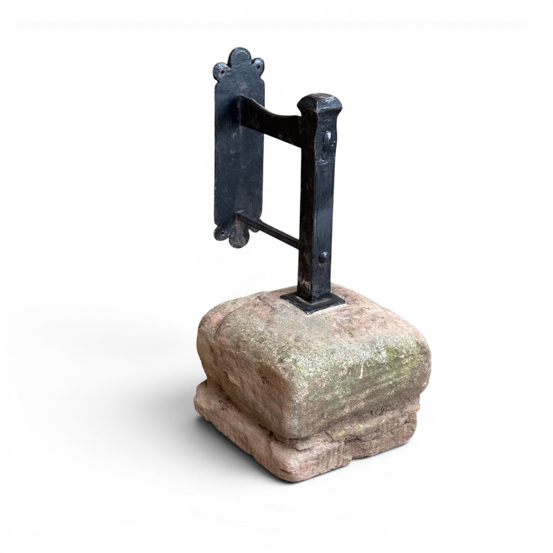 Large wrought metal boot scraper in black painted finish, set in formed stone plinth