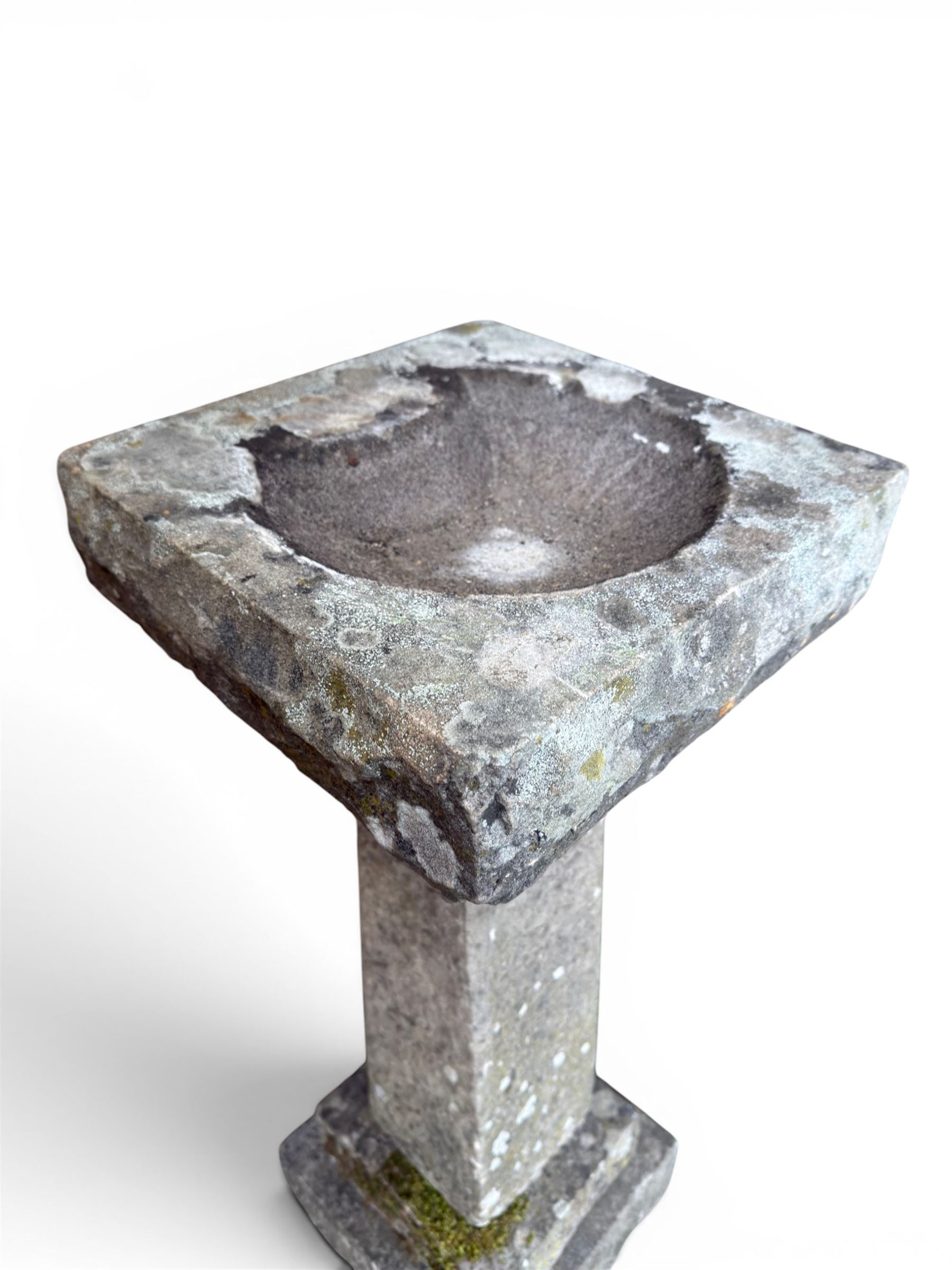 19th century weathered sandstone birdbath, formed in four sections, square top with carved shell bath, raised on tapering column with stepped base