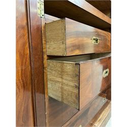 19th century figured mahogany quadruple breakfront press wardrobe, projecting cornice with banded frieze over arch panelled doors, the interior fitted with three sliding trays over two short and three long graduating drawers with recessed brass handles, flanked by two hanging cupboards with hooks