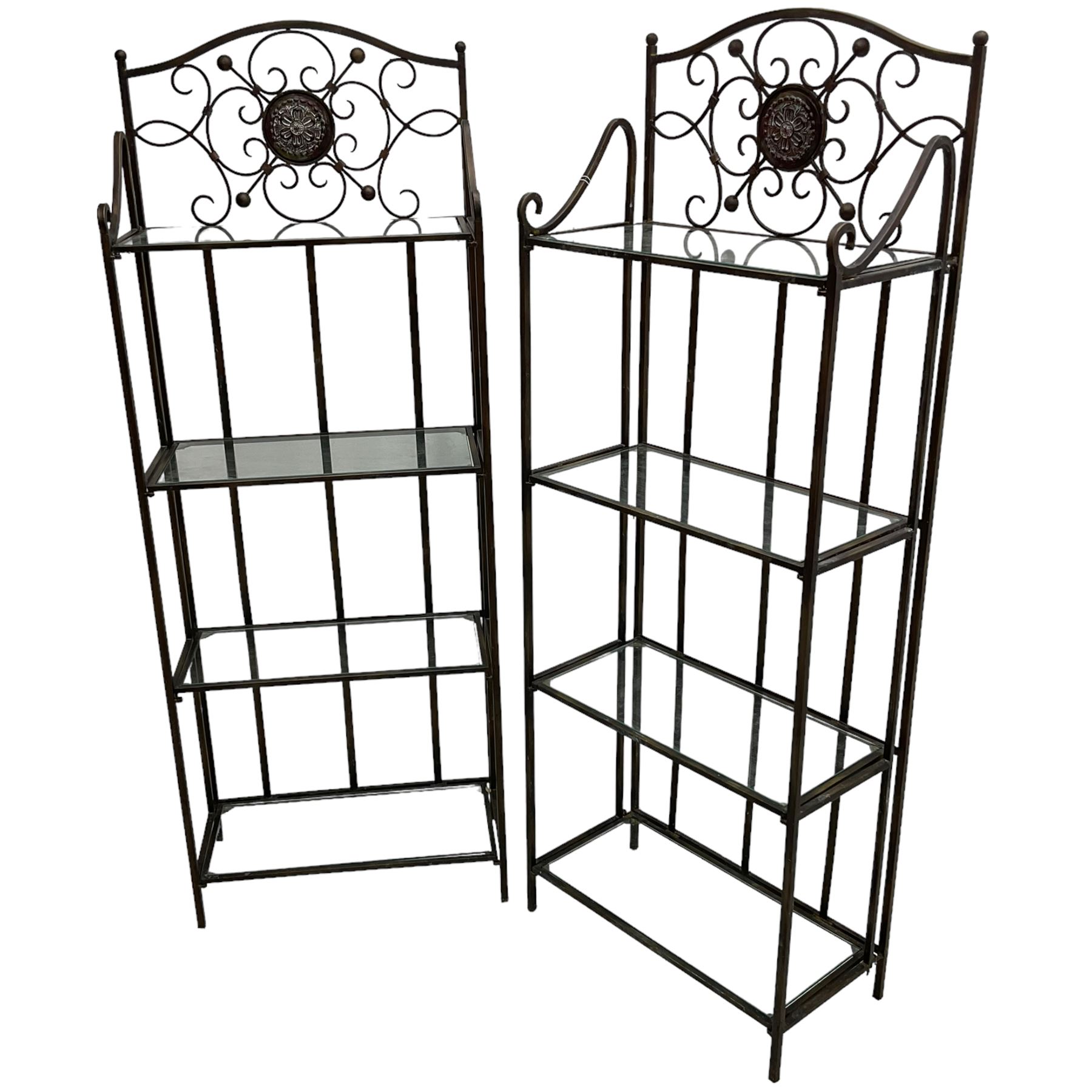 Pair of wrought metal conservatory plant stands, raised back with scrolling design, each fitted with three glass shelves