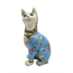 Émile Gallé (French 1846-1904): Faience model of a cat, naturalistically modelled, the head inset with green marbled glass eyes, glazed and painted with flowers on blue ground, the neck decorated with a pendant brooch bearing a portrait of a dog, signed beneath H34cm