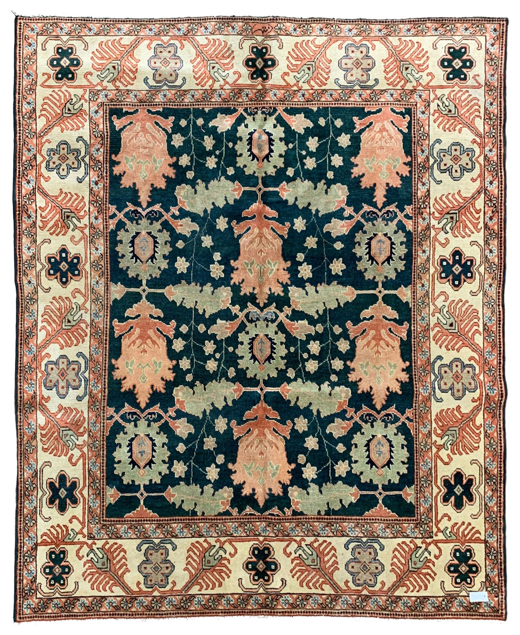Persian emerald green ground rug, the field decorated with large stylised plant motifs, ivory ground border with repeating leaf motifs, the guards decorated with trailing branch and flowerhead motifs
