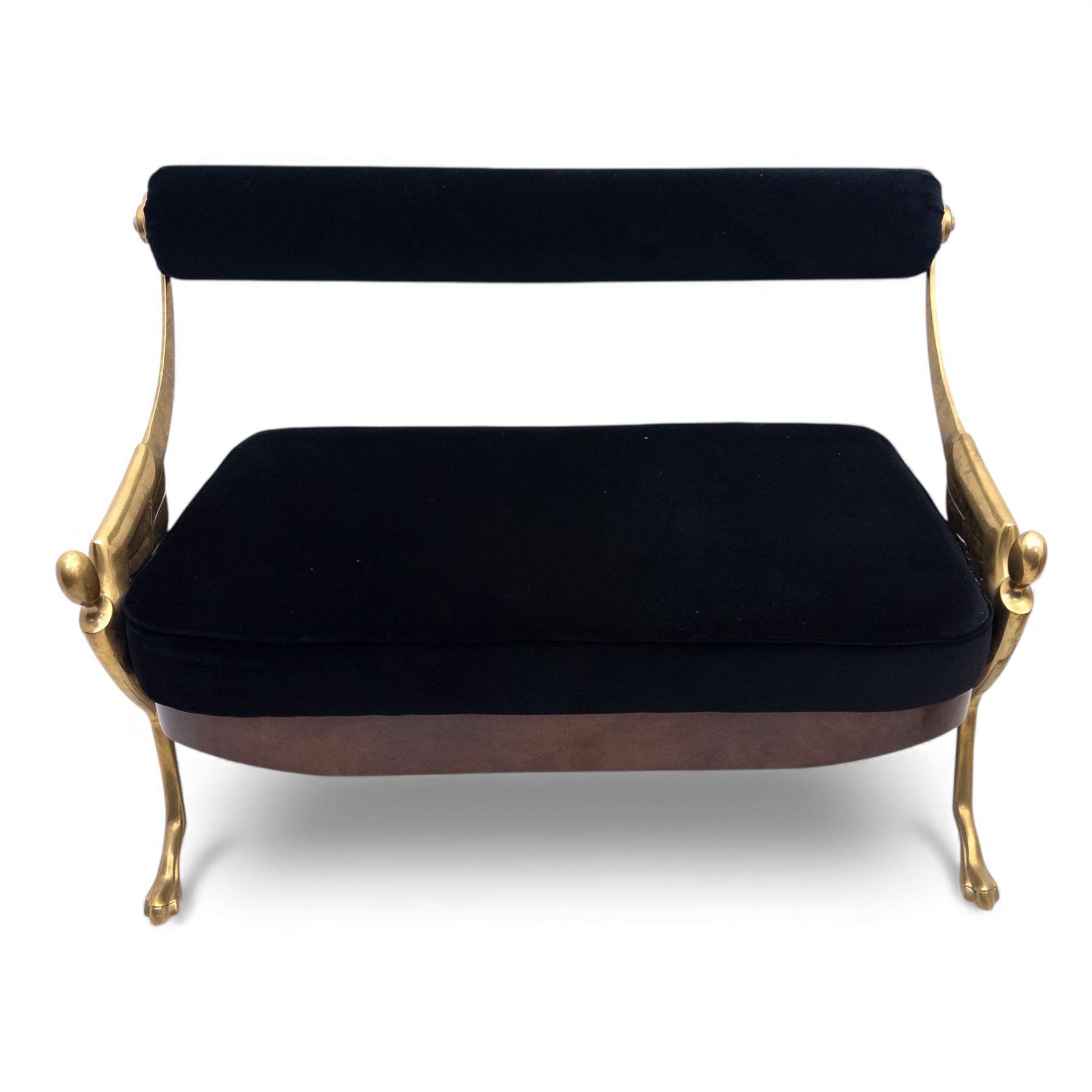 Late 20th century pair of Empire inspired brass metal framed two-seater sofas, upholstered in black velvet with cylindrical backrest and sphinx form arms terminating in paw feet, together with matching deep buttoned black velvet footstool on brass capped legs (Footstool H 38cm, W 70cm, D 70cm)