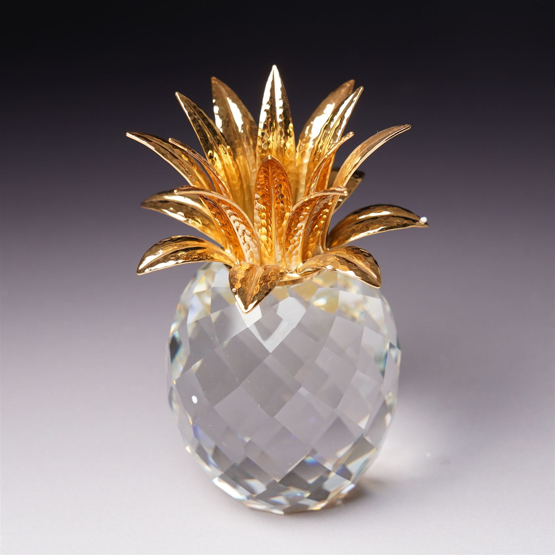 Pair of Swarovski Crystal candlesticks, boxed, together with two paperweights in the form of pineapples with gilt mounts, a large and small example, boxed (4)