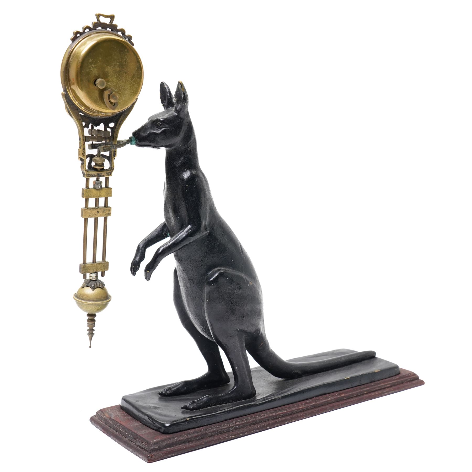  20th century-8-day Marsupial mystery clock with a cast brass patinated model of a standing Kangaroo on a wooden base, with a swinging compound pendulum resting on two steel pivots, white dial with Arabic numerals, minute track and steel spade hands, wound and set from the rear.