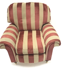  Two seat sofa, scrolled arms, upholstered in a patterned red and gold fabric, turned supports on castors (W180cm) and an armchair upholstered in red and stripped fabric, turned supports on castors (W102cm)  