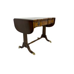 Georgian design mahogany sofa table, shaped drop leaf top over three drawers, on tapered end supports joined by turned stretcher, splayed moulded supports with brass hairy paw cups and castors