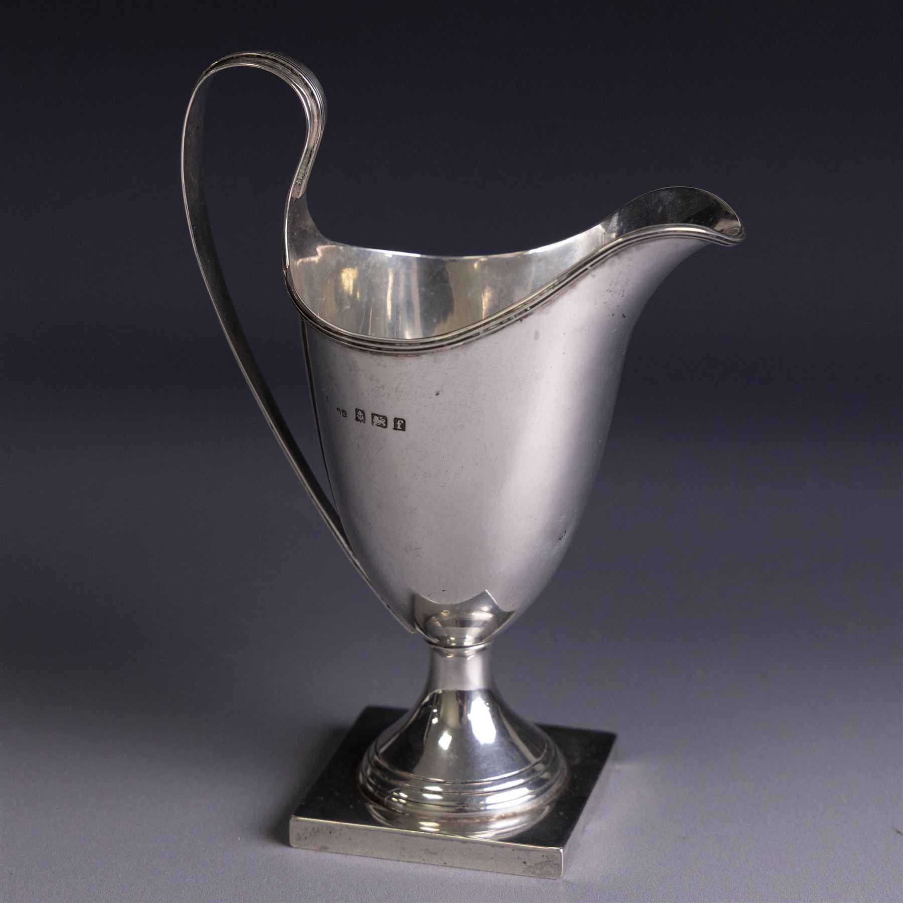 Edwardian silver helmet shaped cream jug, upon a square base, hallmarked John Rose, Birmingham 1905, together with a 1930s silver christening mug with engraved initials to body, hallmarked Aaron Lufkin Dennison, Birmingham 1936, jug including handle H13cm