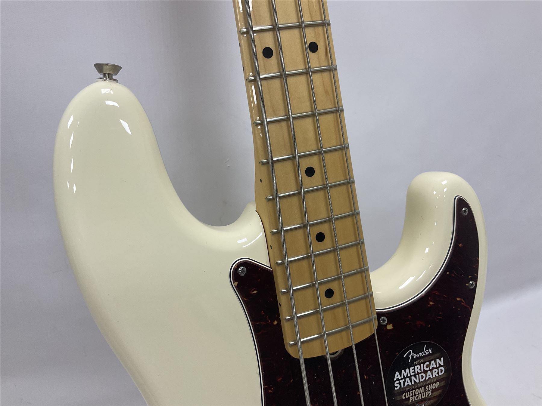 Fender Precision Bass guitar, in Olympic White finish with tortoiseshell effect scratchboard, serial no US15103092, in black Fender hard case with Fender strap and warranty card, guitar L116cm