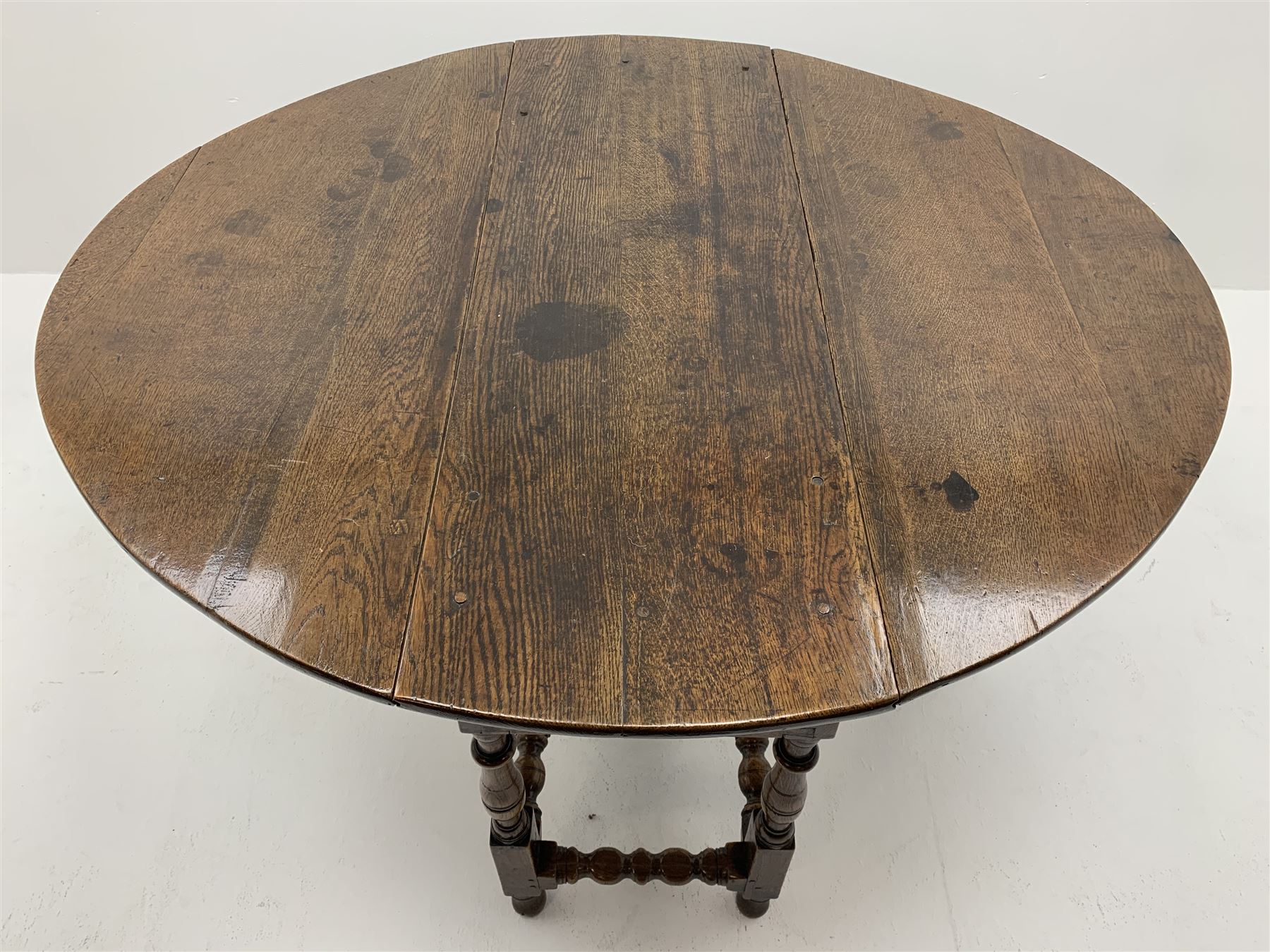 Late 17th century William & Mary oak drop leaf dining table, oval drop leaf top, single drawer to one end, gate action base, turned supports joined by bobbin turned stretchers, 121cm x 135cm, H75cm (open)