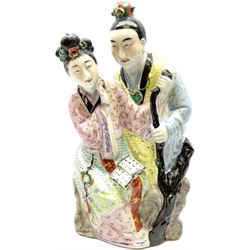 Oriental ceramic figure modeled as a woman reading with a man stood behind her, with stamped mark beneath H39cm.  