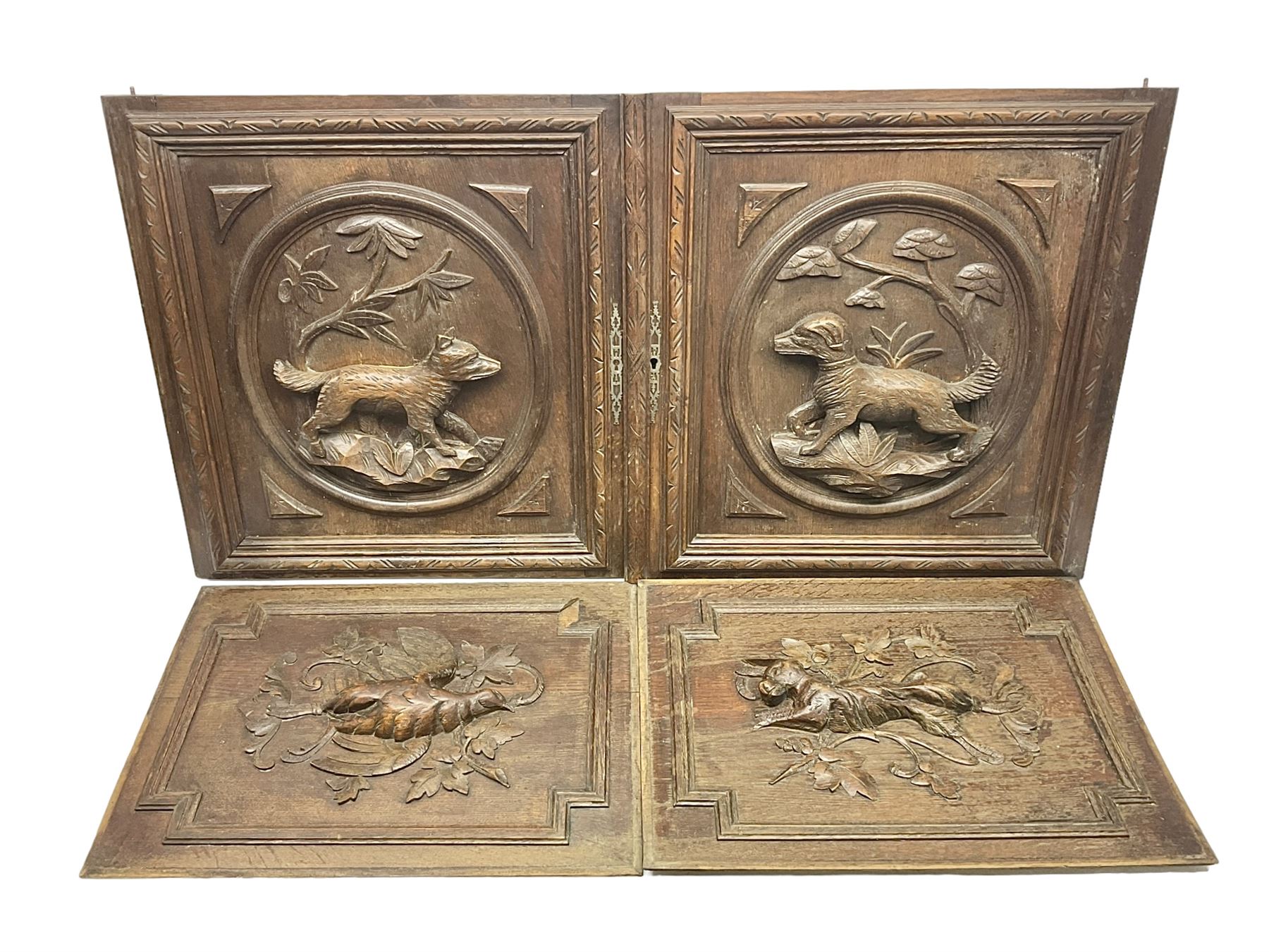 Pair of oak furniture door panels, carved in relief with a fox to one and a hound to the other, together with a pair of smaller oak panels, carved in relief with a hare to one and a grouse to the other, doors W63.cm x H62cm, panels W43cm x H60cm