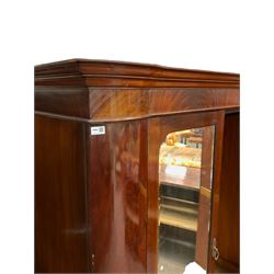 Late 19th century mahogany double wardrobe, projecting cornice over figured frieze, curved uprights enclosing two doors with bevelled mirrors, drawer to base, on splayed bracket feet
