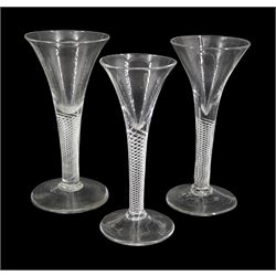 Three 18th century drinking glasses, the drawn trumpet bowls upon single series air twist stems and conical feet, tallest H16.5cm