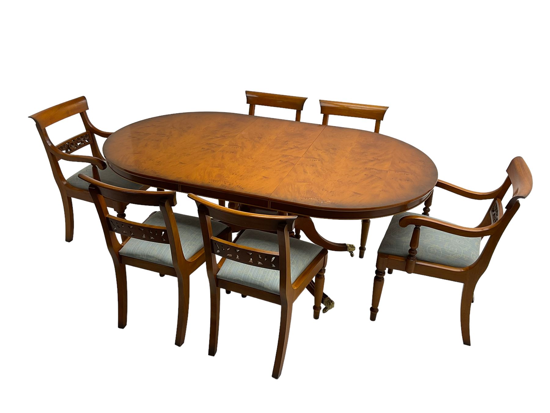 Georgian design yew wood twin pedestal dining table, circular top over four turned columns joined by base, raised on splayed and fluted cabriole supports with paw feet and castors (140cm x 108cm x 77cm); with set six (4+2) Georgian style yew wood dining chairs, middle rail pierced and carved with flowerhead and extending foliage, upholstered drop in seat, raised on turned tapering supports (50cm x 47cm x 86cm)