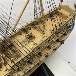 Wooden kit built model of HMS Neptune, 1:90 scale, with detailed rigging to three masts and a row of cannons to either side, upon ebonised wooden base, including stand H71cm