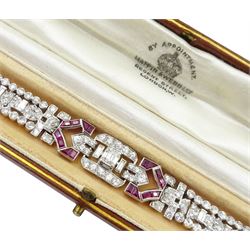 Art Deco platinum diamond and ruby bracelet, circa 1920-1930, the central panel set with a single emerald cut diamond of approx 0.55 carat, flanked by two baguette cut diamonds and old cut diamond surround, the articulated geometric design bracelet with vari-cut rubies, round and baguette cut diamonds, total diamond weight approx 7.00 carat, in Mappin & Webb silk and velvet lined box