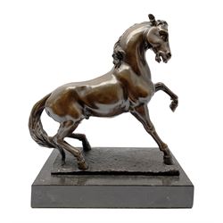 Bronze figure modelled as a prancing horse, upon a naturalistically modelled rectangular base, and black marble plinth, H34.5cm, L31cm
