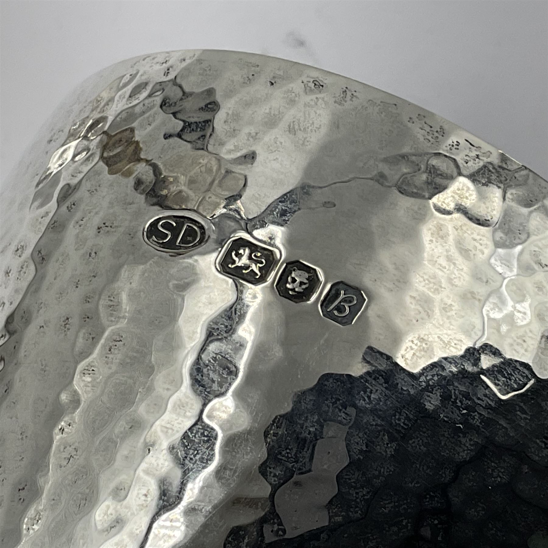 Pair of modern silver goblets by Stuart Devlin, the tapering cylindrical bowls each with spot hammered decoration and gilt interiors, the parcel gilt stems with signature textured detailing and six graduating knops, upon conforming spreading circular foot, hallmarked Stuart Devlin, London 1976, H17.7cm